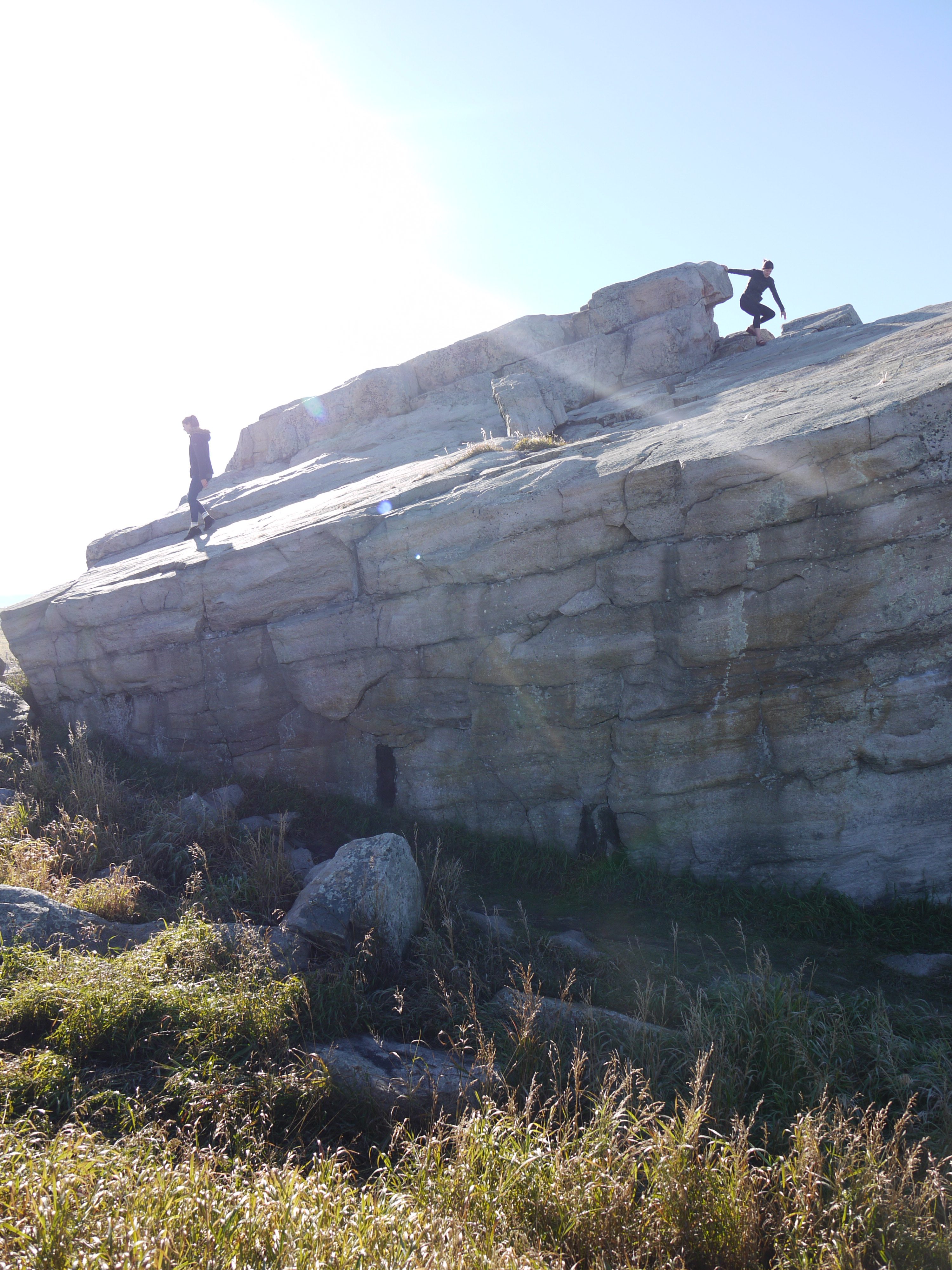 Visitors climbing on the 'Big Rock' which could potentially cause damage to the rock and pictograph panels.