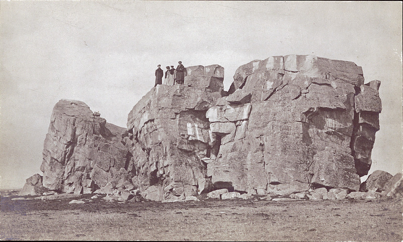 Four men standing at the top of the Big Rock at Okotoks, Alberta, ca. 1920.