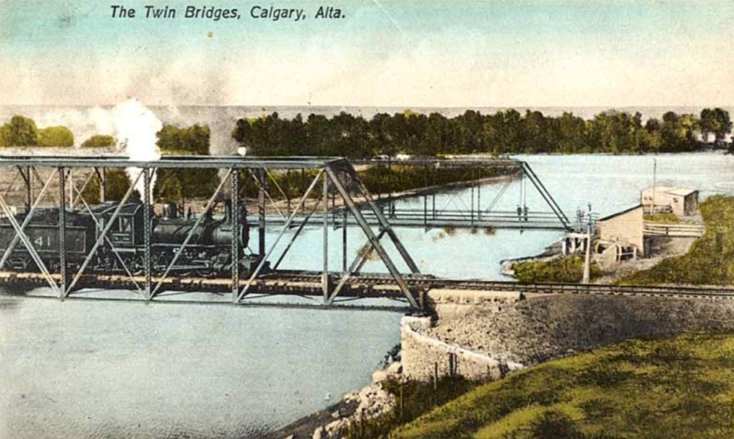 The forerunner to the existing 9th Avenue SE Bridge is seen behind the CPR bridge in this c1909 postcard.