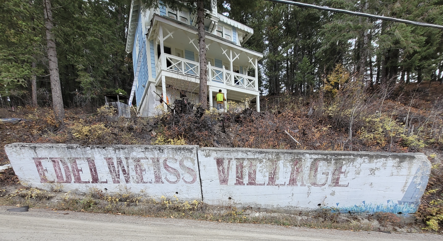 Blue chalet standing over the Edelweiss Village sign at the entrance. During documentation and renovations, October 2023. From Capture2Preserv project.